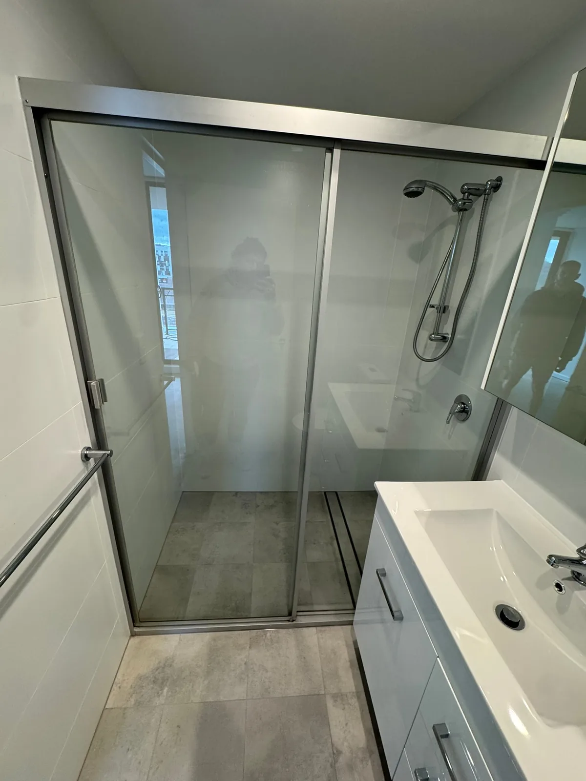 Sliding shower screen and vanity in a finished bathroom with tiled floor