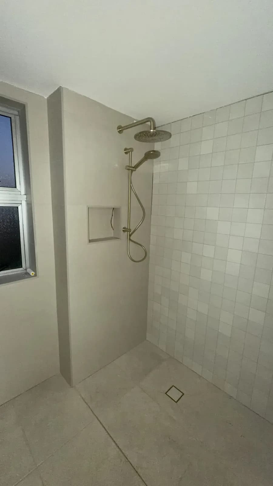 Tiled shower recess with a rain head and a flush floor waste