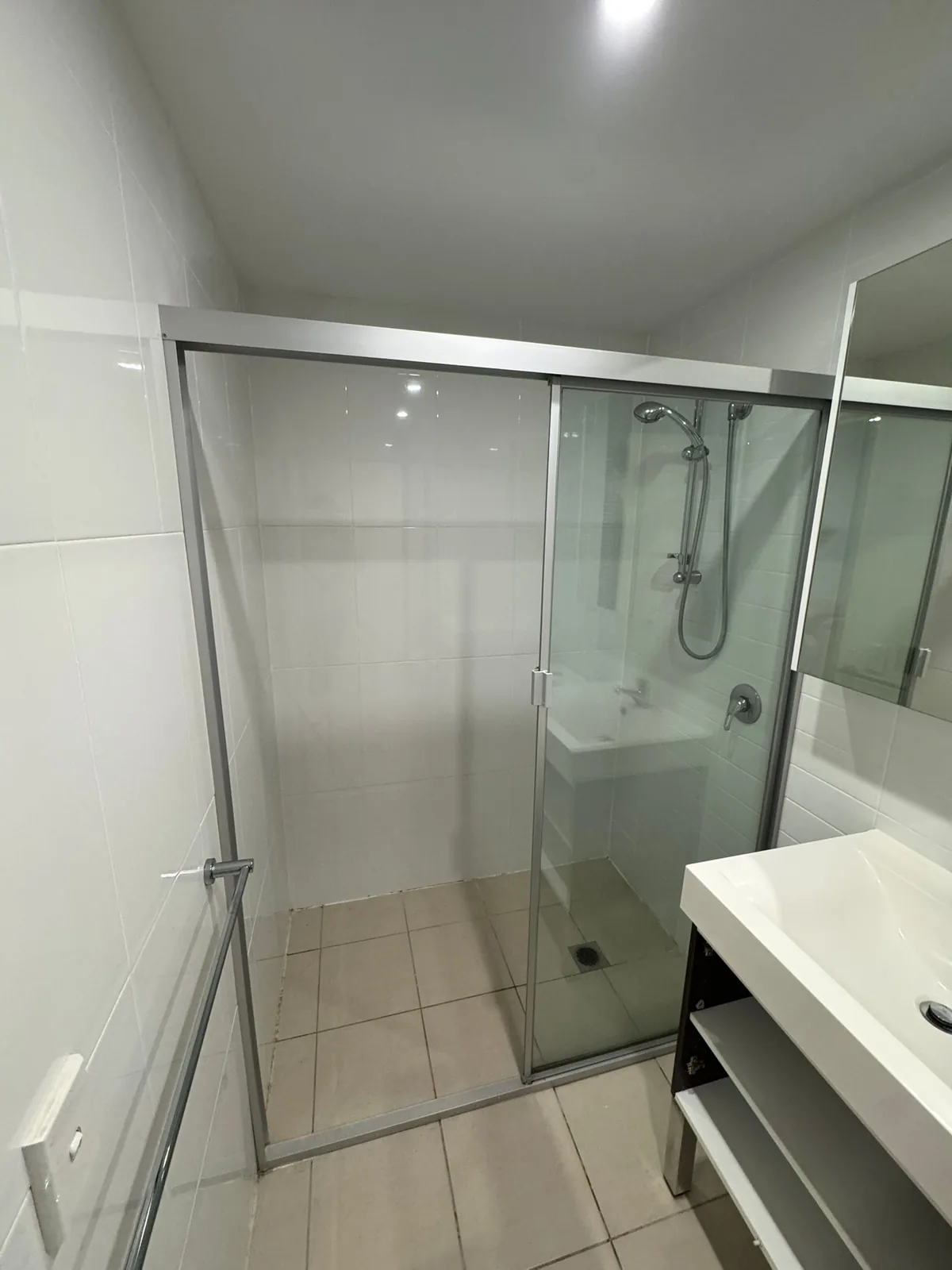 Old framed shower screen and tiling before the bathroom was stripped out