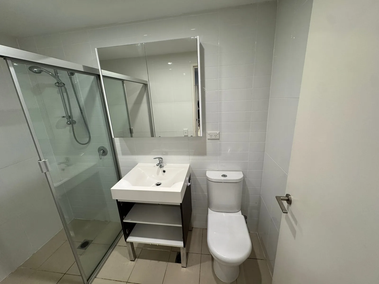 Original bathroom layout before renovation, with a freestanding vanity and framed screen