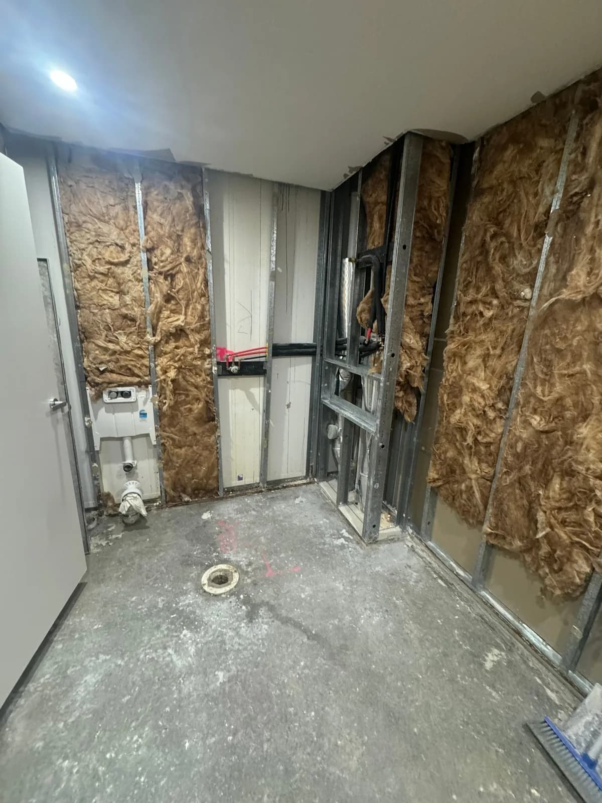 Bathroom stripped back to stud framing, ready for new wall linings