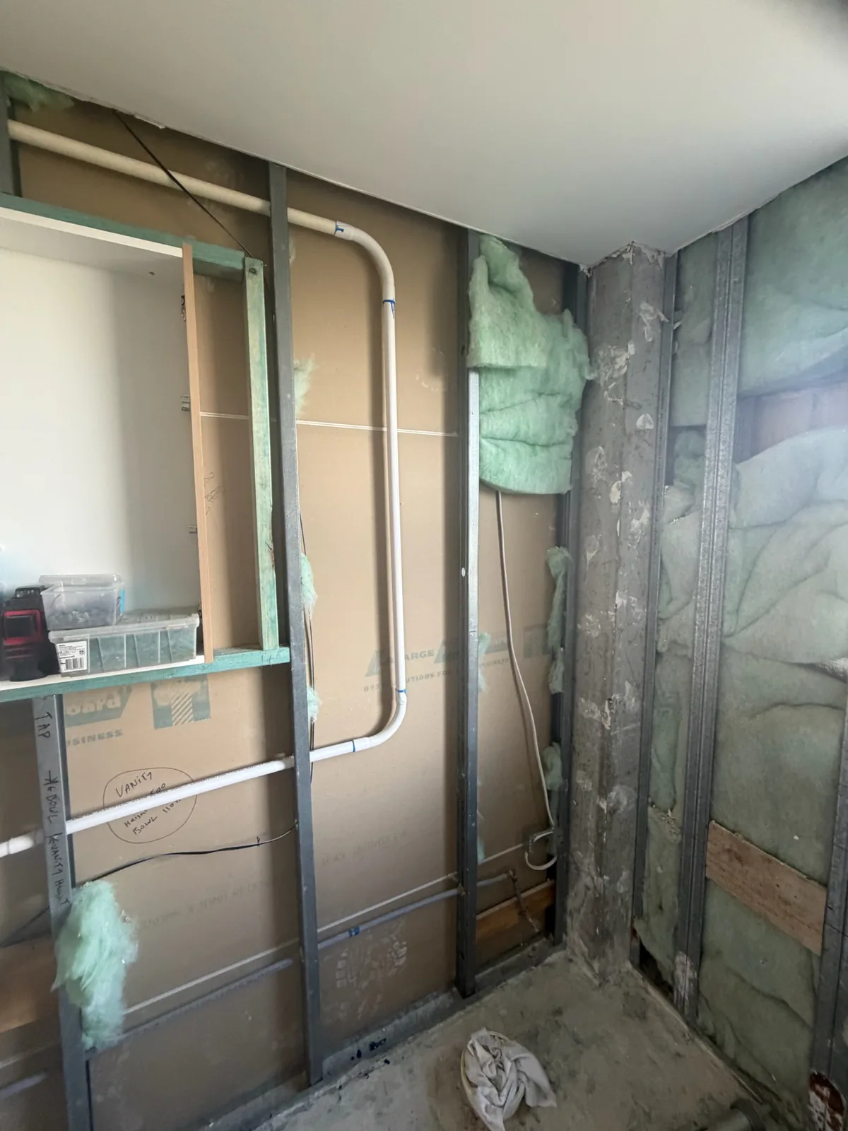 Framed recess for a built-in shaving cabinet with plumbing and wiring run behind