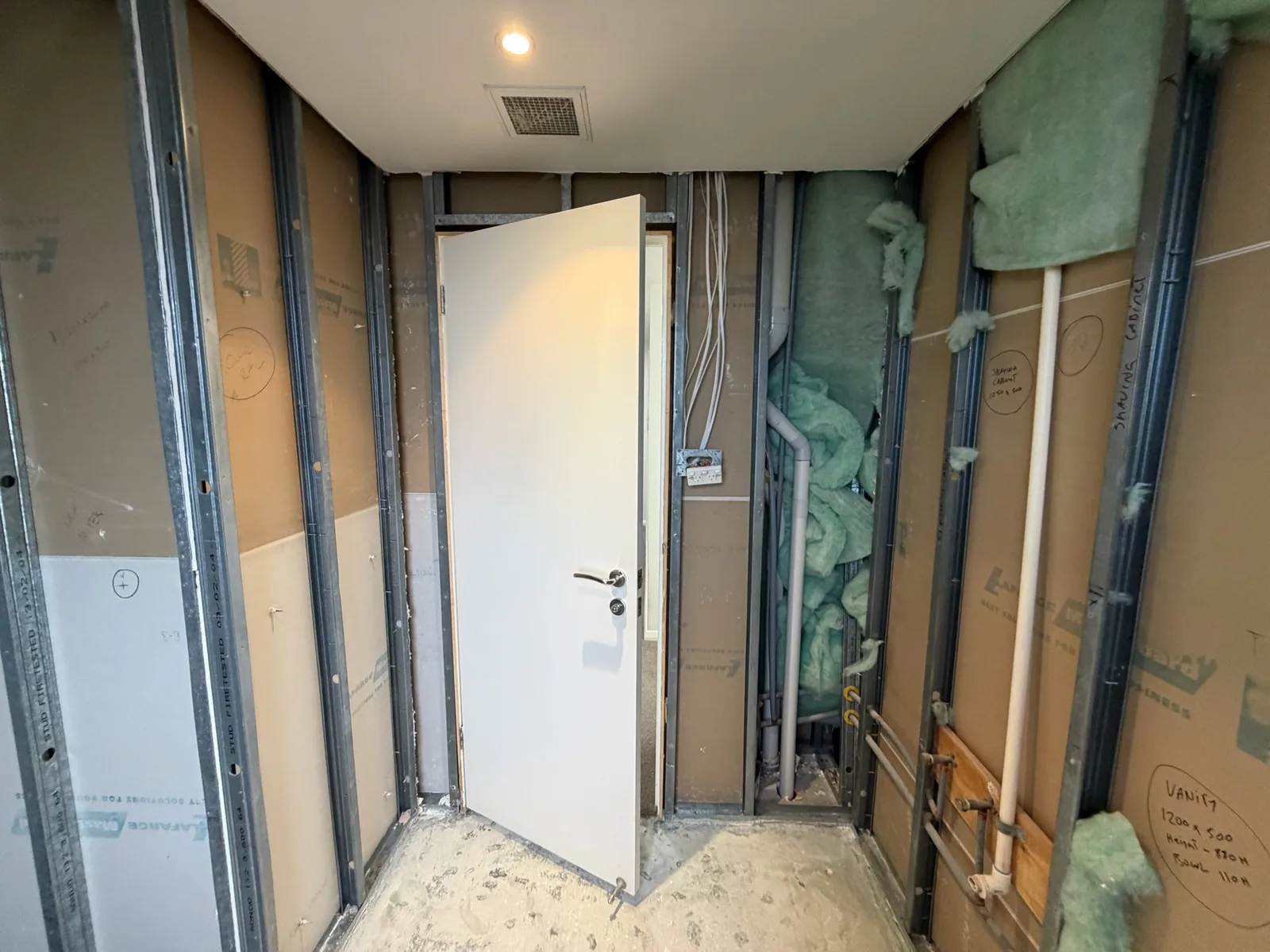 New door and frame installed into a freshly framed bathroom opening