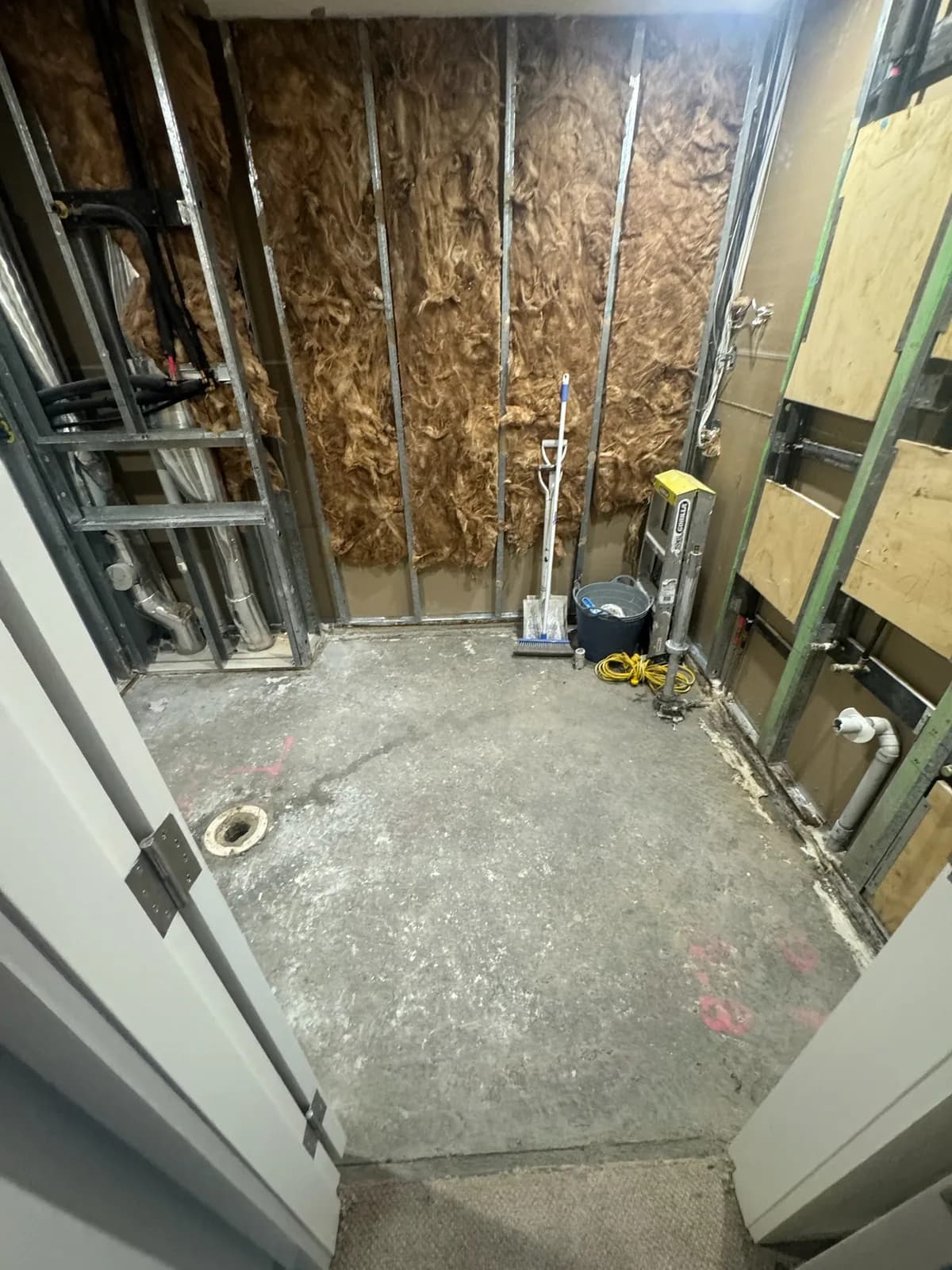 Bathroom framing with plumbing and electrical services roughed in before lining