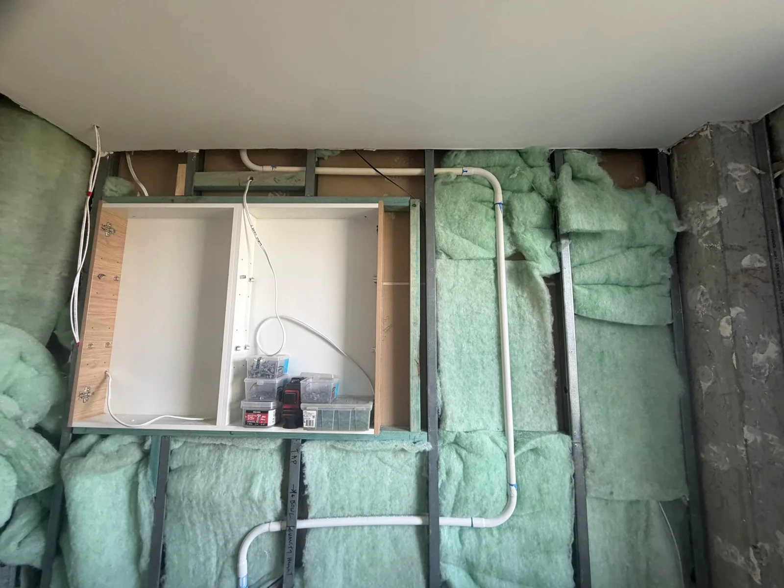 Insulated steel wall frame with plumbing set out before wall linings go on