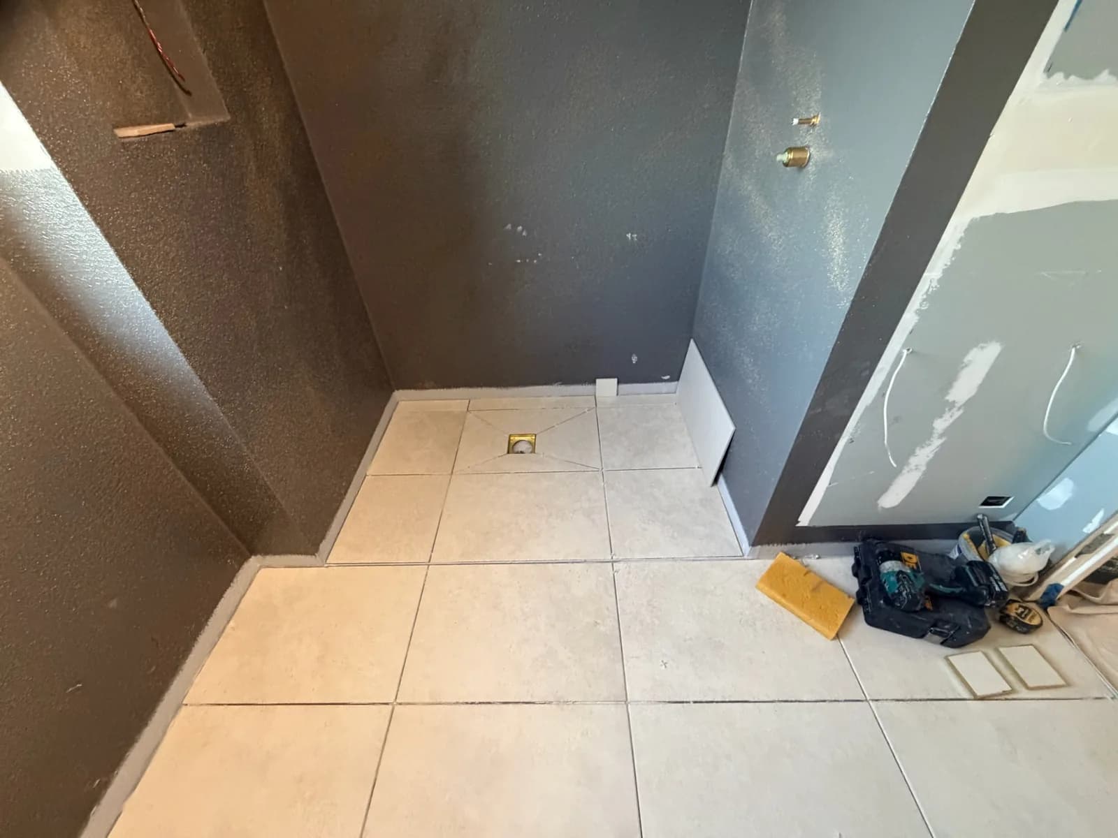 Floor tile set-out running square into the shower area before grouting