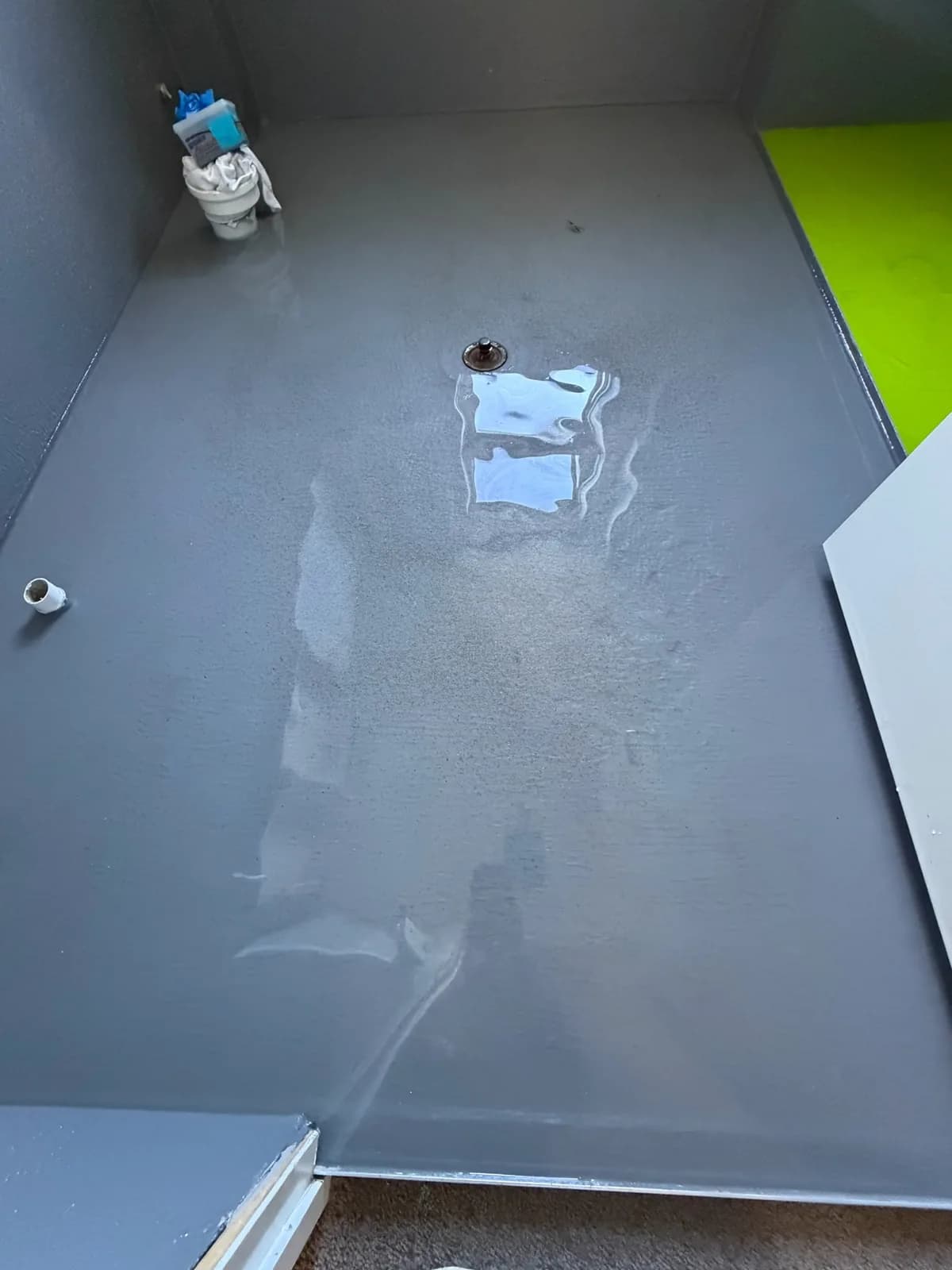 Waterproofing membrane over a bathroom floor graded to fall toward the waste