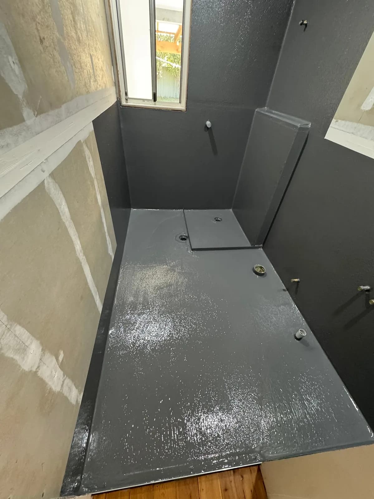Membrane applied over a shower hob and stepped floor before tiles go down