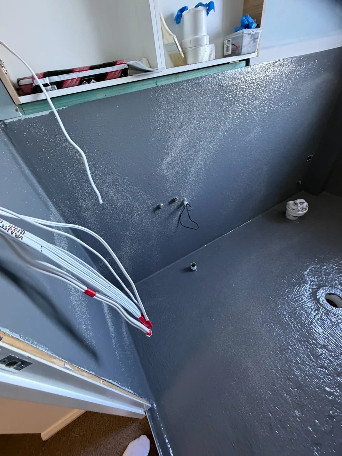 Second coat of waterproofing membrane going onto a bathroom floor and walls