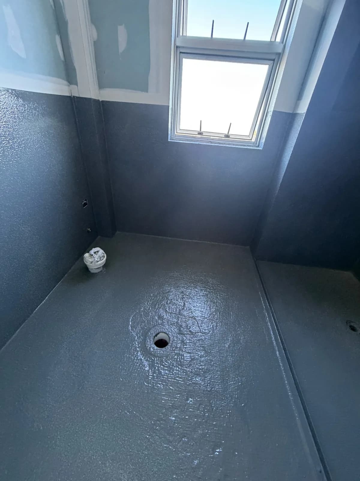 Bathroom wet area with charcoal waterproofing membrane applied to the floor and walls